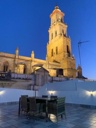 a building with a tower with a table and chairs at Torre de Santa María in Utrera