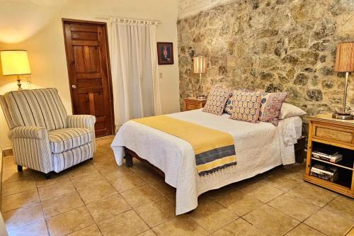 a bedroom with a bed and a chair at Casa Maria en La Manzanilla in La Manzanilla