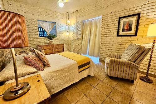 a bedroom with a bed and a chair at Casa Maria en La Manzanilla in La Manzanilla