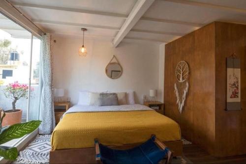 Un dormitorio con una cama y una ventana grande. en Departamentos Mi querido Coyoacán, en Ciudad de México