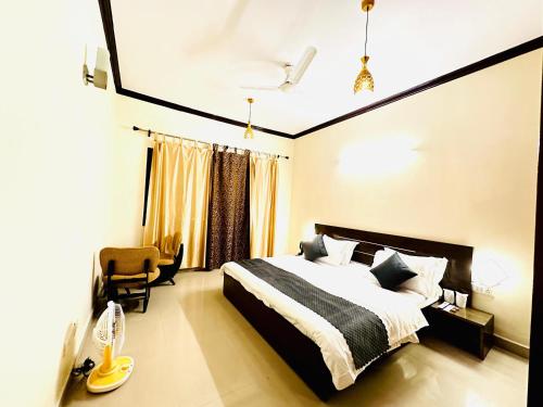 a bedroom with a bed and a chair at Manor Villa by Veda Hotels in Bhowāli
