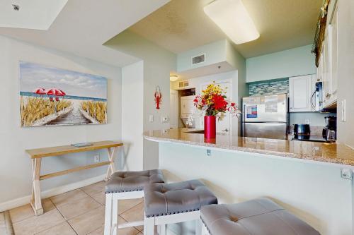 a kitchen with a counter and two stools at Shores of Panama 2310 in Panama City Beach