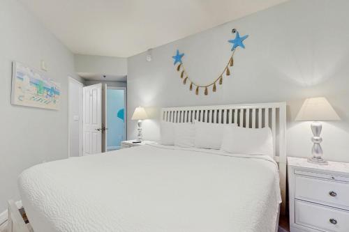 a bedroom with a white bed with stars on the wall at Shores of Panama 2310 in Panama City Beach