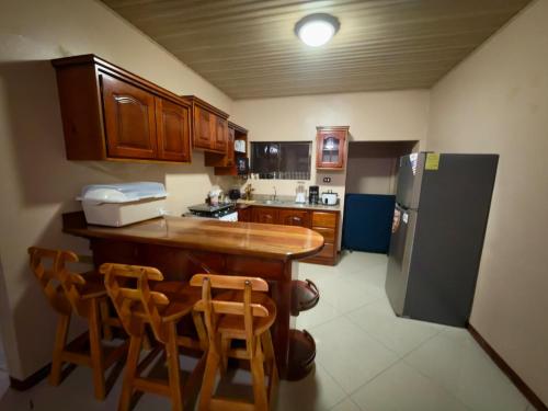 a kitchen with a wooden table and a refrigerator at Hospedaje Nacho y Ale No 2, Paso Canoas, Costa Rica in Canoas