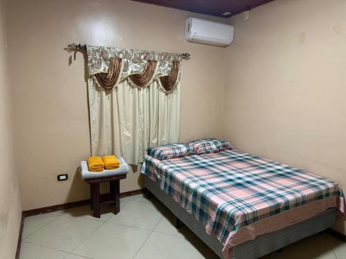 a small bedroom with a bed and a window at Hospedaje Nacho y Ale No 2, Paso Canoas, Costa Rica in Canoas