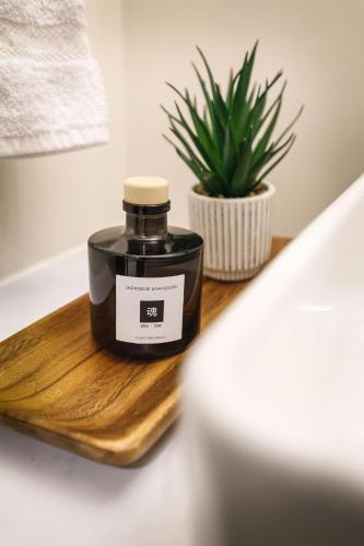 a bottle of soy candle on a wooden tray with a plant at Westwinds - Funky Basecamp in the Rockies in Canmore