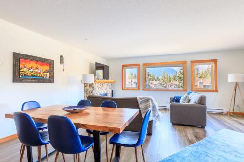 a living room with a wooden table and blue chairs at Bluebird - Spacious Luxury Shared Rooftop Hot Tub in Canmore