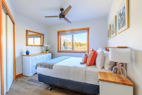 a bedroom with a bed and a window at Bluebird - Spacious Luxury Shared Rooftop Hot Tub in Canmore
