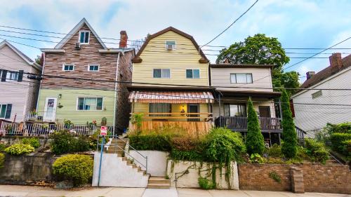 a yellow house with a fence in front of it at Massive 4 Bed House-Short Walk to Amazing View in Pittsburgh