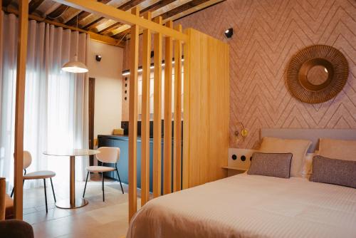 a bedroom with a bed and a table in a room at Hotel Spa Los Mercaderes in Talavera de la Reina