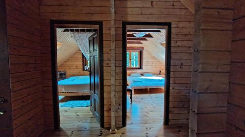 two doors in a room with two beds at SOVA House in Kruczy Borek