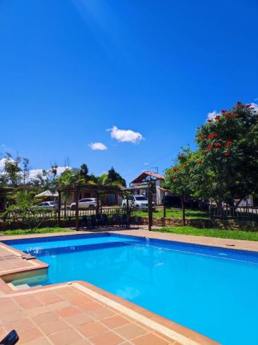 a swimming pool with blue water in a yard at San Rafael del Campo - Barichara in Barichara
