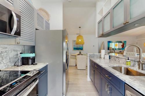 a kitchen with stainless steel appliances and blue cabinets at Manasota Key Dream in Englewood