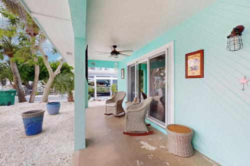 a blue house with chairs and a ceiling fan at Manasota Key Dream in Englewood