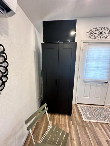 a room with a black cabinet and a door at Tiny house - Our little piece of paradise in Lakehills