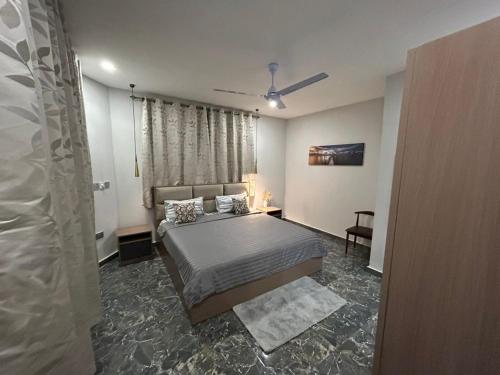 un dormitorio con una cama y una ventana en OB DELUXE Apartments 1, en Accra