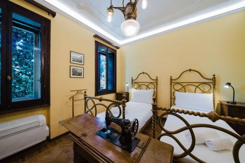 a bedroom with two beds and a desk and a bed sidx sidx sidx at Antico Villino - Elegant Accommodation with Parking in Conegliano
