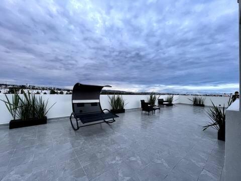 a chair sitting on a patio next to a body of water at Living Universidad in El Gallinero