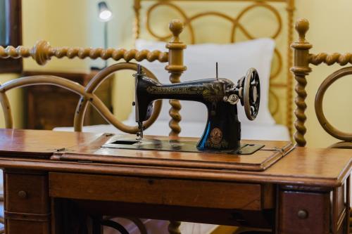 an old sewing machine sitting on a wooden table at Antico Villino - Elegant Accommodation with Parking in Conegliano
