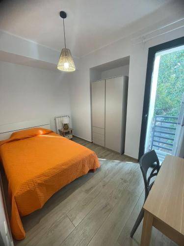 an orange bed in a white room with a table at "O Funnucu Baruni" in Giarre