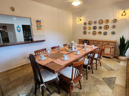 a dining room with a large wooden table and chairs at Casa em Itamambuca com piscina em frente a praia in Ubatuba