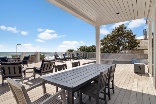 a wooden deck with a wooden table and chairs at Sea Castle by 30A Escapes in Sunnyside