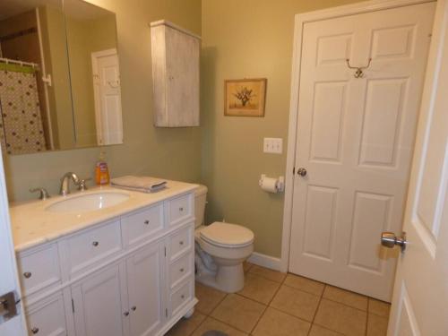 a bathroom with a white sink and a toilet at Woodland Retreat At Finch Creek in Bellaire