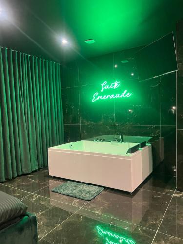 Suite Emeraude في سانت إتيان: حمام مع حوض استحمام ولافتة نيون
