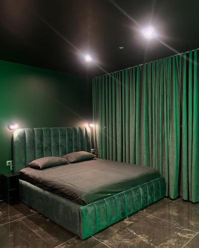 Suite Emeraude في سانت إتيان: سرير في غرفة بها ستارة خضراء