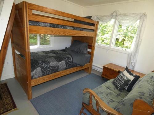 a bedroom with two bunk beds and a couch at Woodland Retreat At Finch Creek in Bellaire