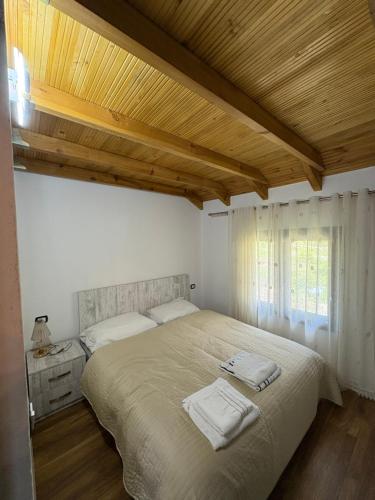 une chambre avec un grand lit avec deux serviettes dessus dans l'établissement Bujtina Halili Gjinar Two Bedrooms, à Gjinar