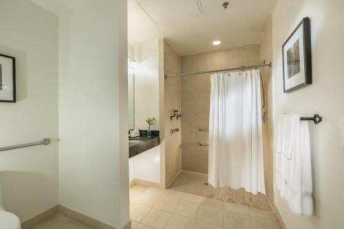 a bathroom with a shower with a white shower curtain at International House Hotel in New Orleans