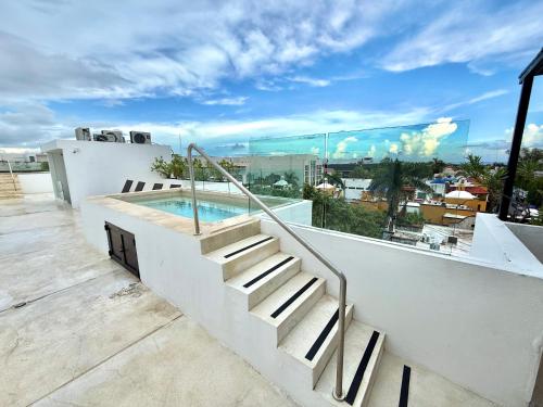 a balcony with stairs and a swimming pool on a building at Anah Suites by Las Flores Vacation Rentals in Playa del Carmen