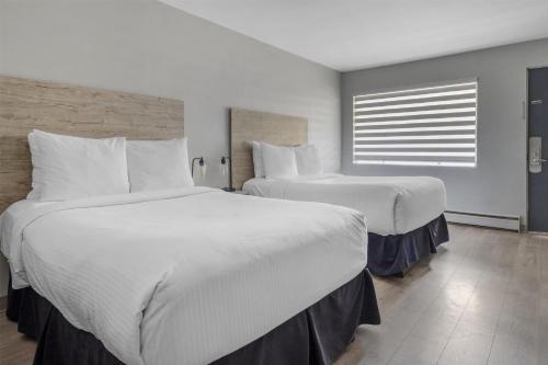 a hotel room with two beds and a window at Dannys Suites, SureStay Collection by Best Western in Beresford