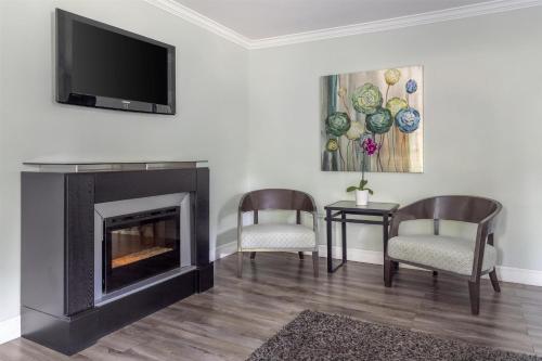 a living room with two chairs and a fireplace at Dannys Suites, SureStay Collection by Best Western in Beresford