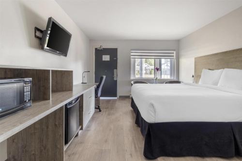 a hotel room with a large bed and a tv at Dannys Suites, SureStay Collection by Best Western in Beresford