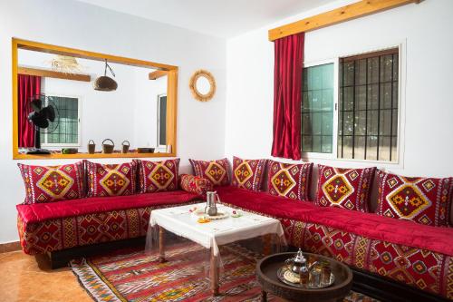 a living room with a red couch and a table at Paradise Farm 20 min from Rabat in Sale