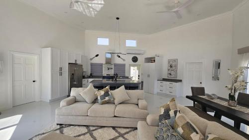 a living room with a couch and a kitchen at Porpoise Paradise Luxury Villa 