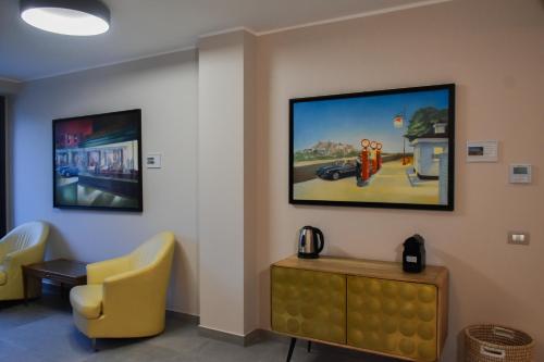 a waiting room with a yellow chair and a tv at Le vie del mare , Ribolla in Ribolla