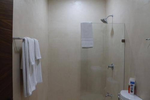un bagno con doccia con porta in vetro di Casa Esquina Suite 1 a Mérida