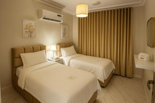 阿可贺巴Comfortable three-bedroom apartment in Olaya的有两张床和一扇窗户的酒店房间