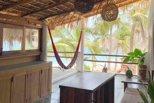 a room with a hammock in the middle of a house at Casa Estrella Fugaz Rinconcito Mazunte in Santa María Tonameca