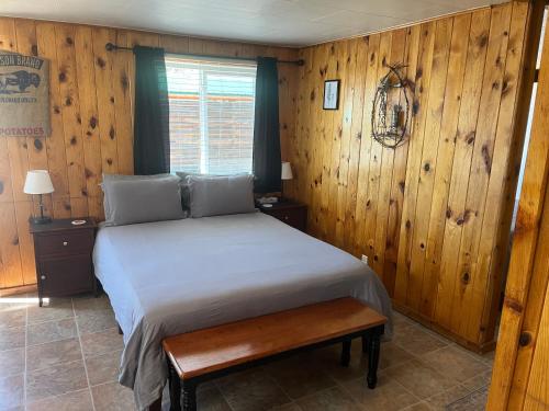 a bedroom with a bed and a wooden wall at Cozy cabin #6 at Aspen Ridge Cabins in South Fork