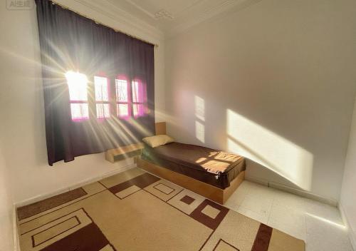 a room with a bed in a room with a window at Your new comfortable home with us in Laayoune