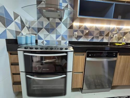 eine Küche mit Herd und Spüle in der Unterkunft Alto Padrão, Vista Mar, Varanda Gourmet, Nascente Compartilhar SalvarHigh Standard, Sea View, Gourmet Balcony, East-facing in Guarapari