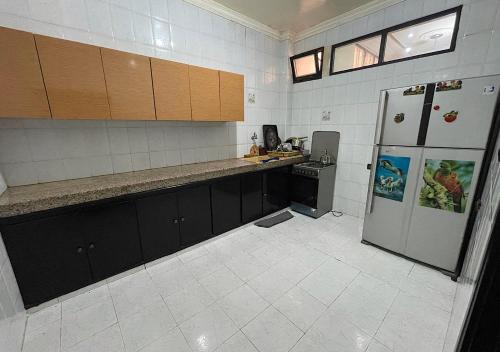 an empty kitchen with a refrigerator and a stove at Your new comfortable home with us in Laayoune