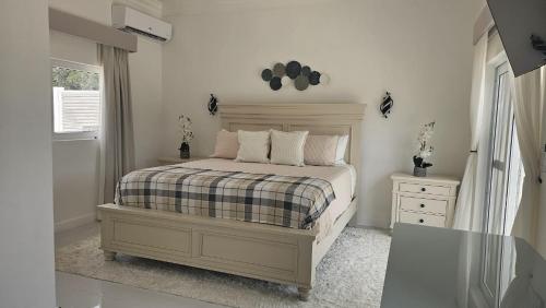 a bedroom with a bed and a dresser and a window at Porpoise Paradise Luxury Villa 