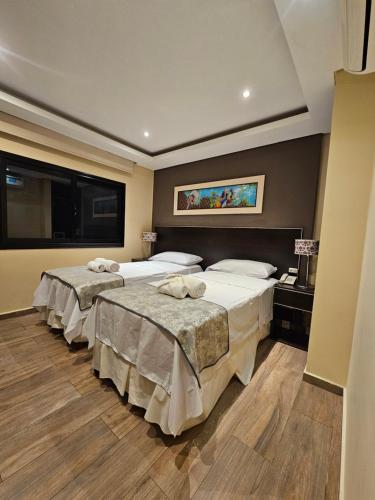 a hotel room with three beds and a window at Hotel Grand Lago in Posadas