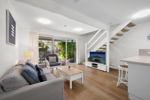 a living room with a couch and a tv at Peaceful Garden Escape - 2BR Noosaville Getaway in Noosaville