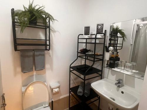 a bathroom with a toilet and a sink and a mirror at Zhafira Retreat in Manila